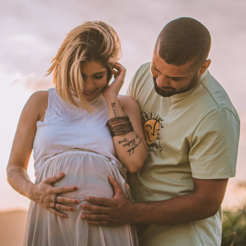 Couple holding pregnant mother's tummy